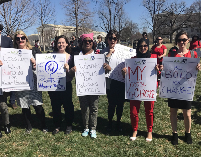 group of 7 young protesters near the U.S. Capitol holding signs encouraging the promotion of civil rights.