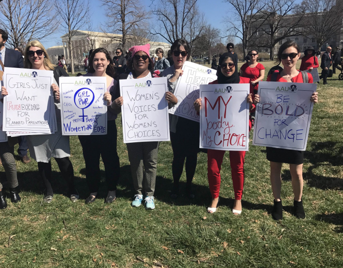 group of 7 young protesters near the U.S. Capitol holding signs encouraging the promotion of civil rights.