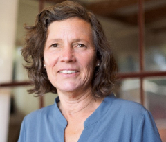 headshot photo of Professor Jennifer Freyd wearing a blue shirt sitting in front of a window