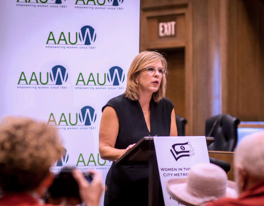 AAUW CEO Kim Churches stands at a podium speaking at press conference.