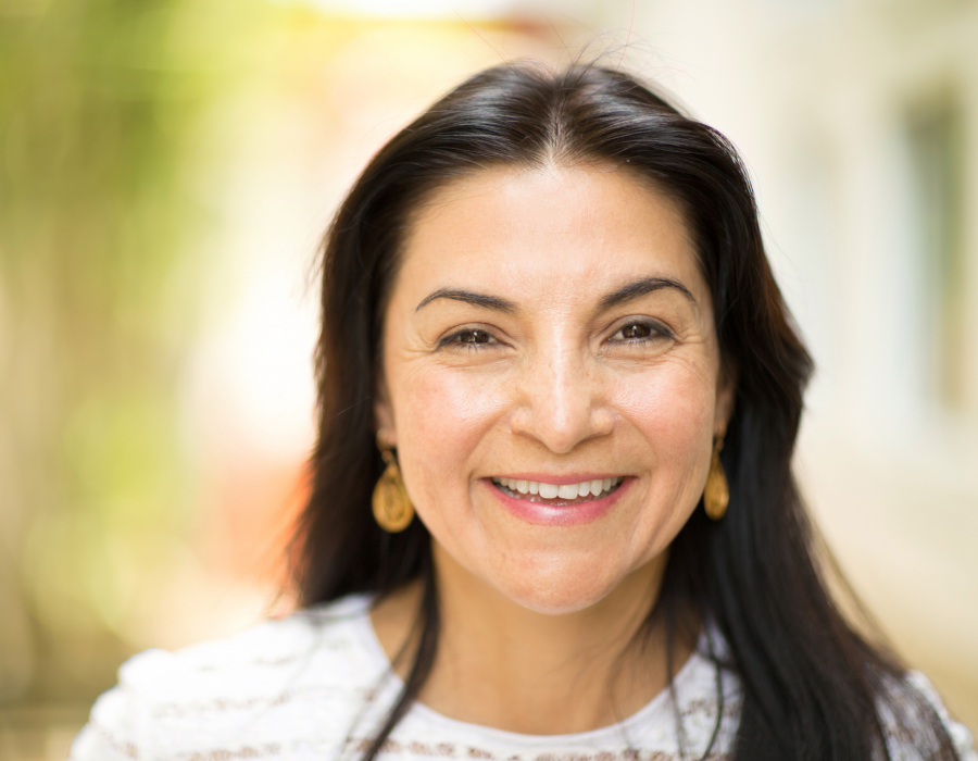 Picture of a Latina smiling in an outdoor setting.