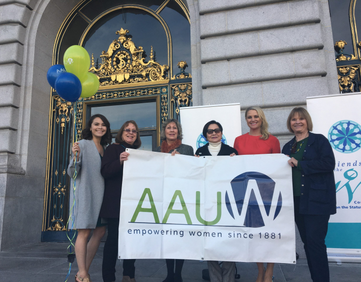 AAUW members holding a sign