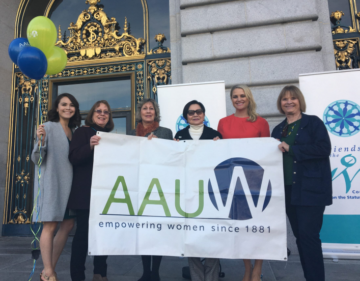 AAUW members holding a sign