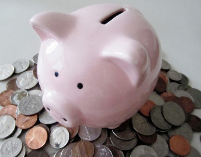 A piggy bank on a pile of coins, signifying a pay day