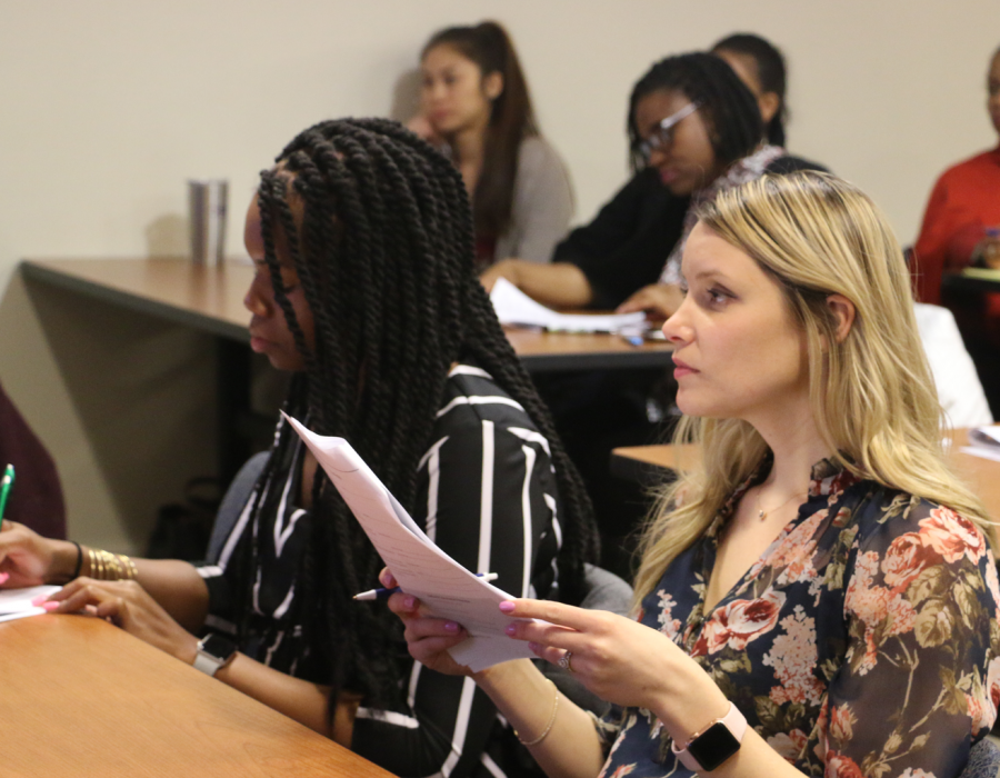 one black women and one white woman sitting in a work smart workshop going over notes