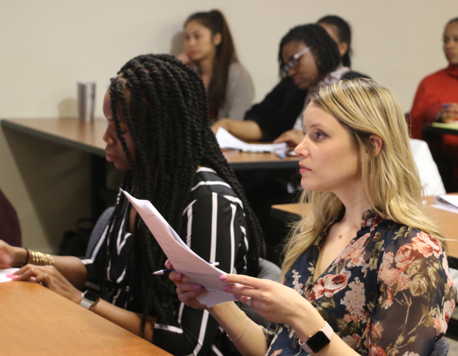 one black women and one white woman sitting in a work smart workshop going over notes