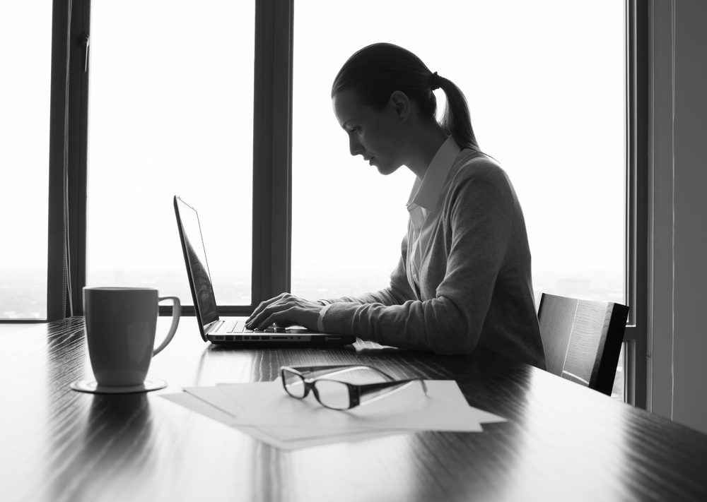 A businesswoman using a laptop in a conference room
