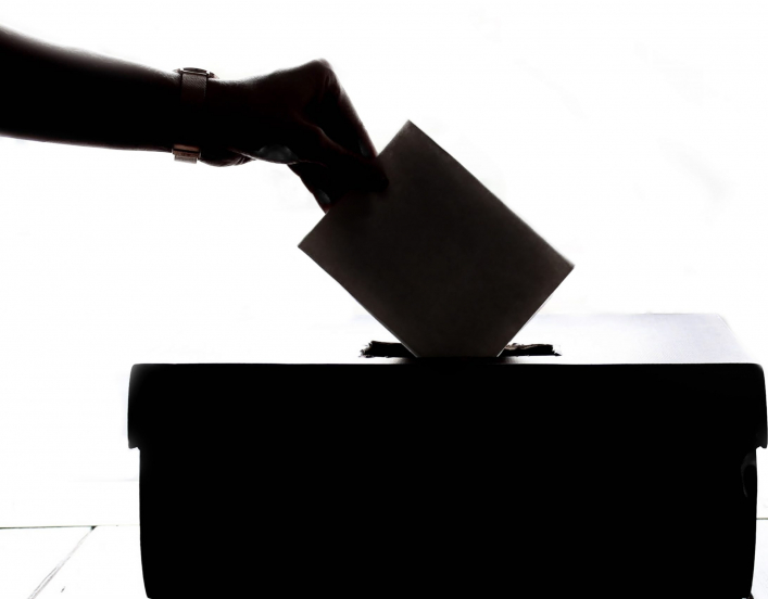 hand putting paper ballot in box (photo by Element 5 Digital for Unsplash)