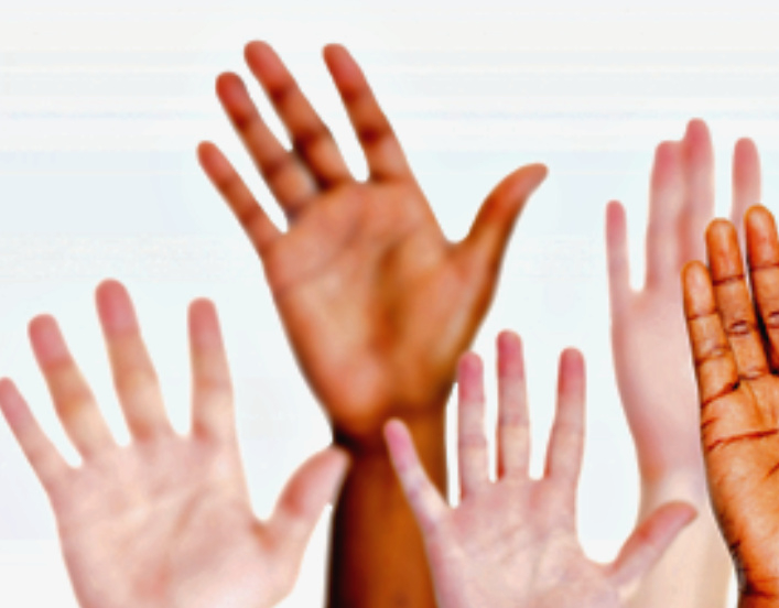 a group of raised hands in a vareity of skin hues