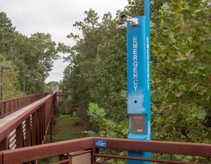 Emergency blue light on campus in quiet wooden foot path area