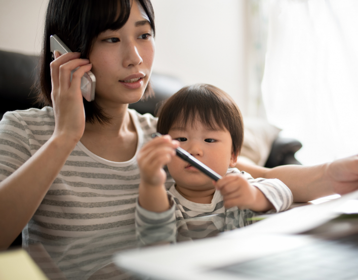 Woman in front of a laptop with her son on her lap