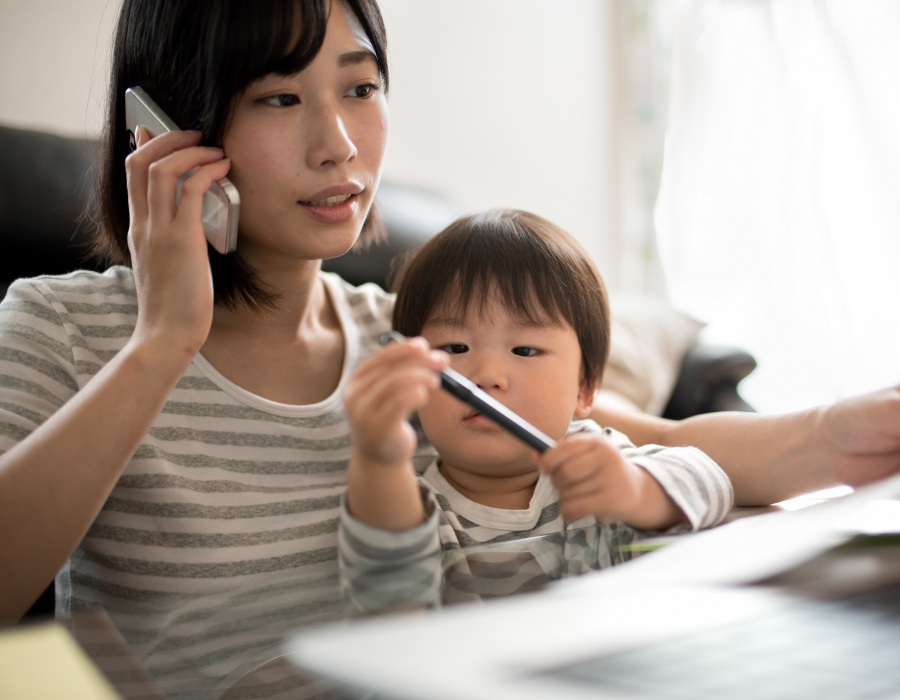 Woman in front of a laptop with her son on her lap