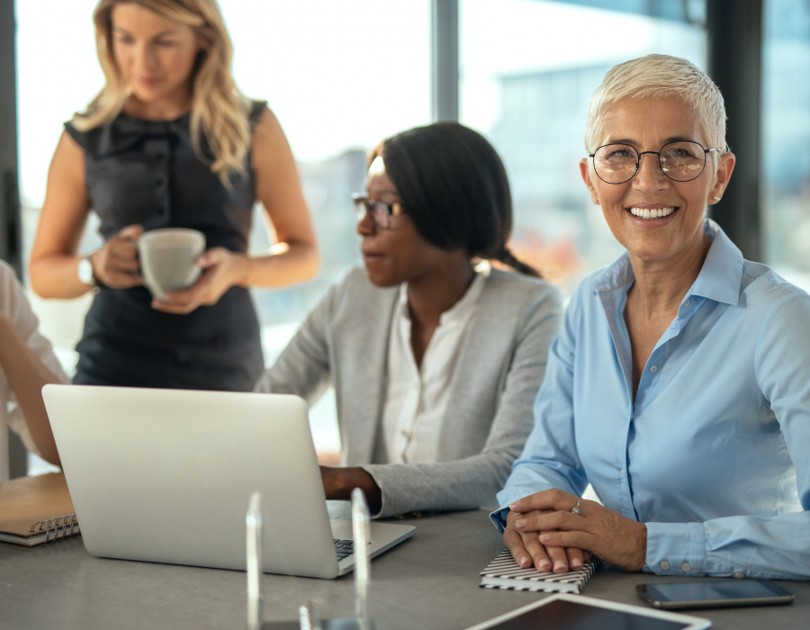 Group of female businesswomen working together on a laptop.