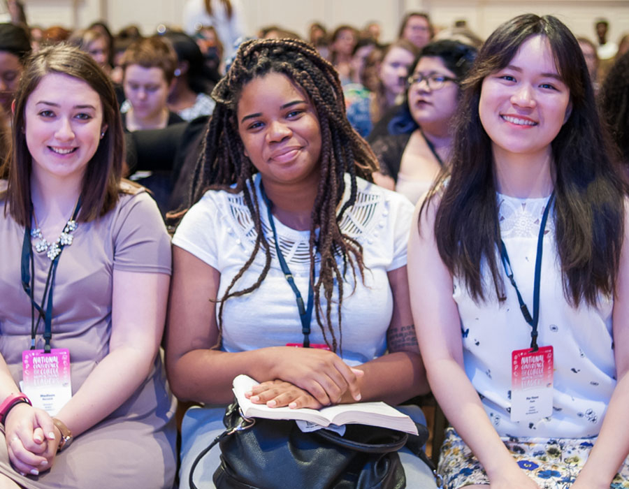 three students attending NCCWSL waiting for the next speaker to start.
