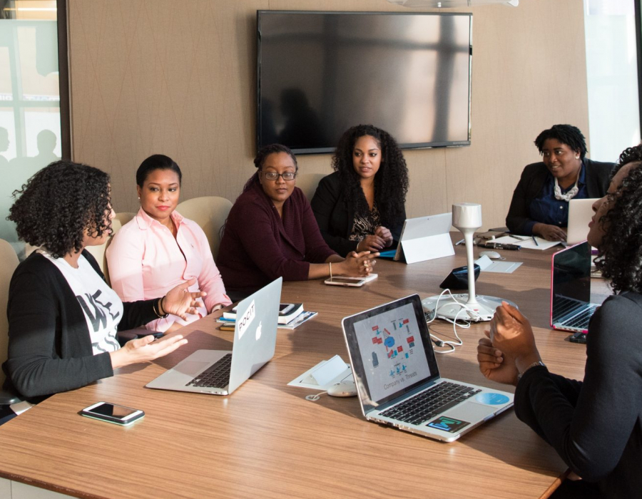 Black women around a conference table in an office, courtesy of Christina @ wocintechchat.com for Unsplash