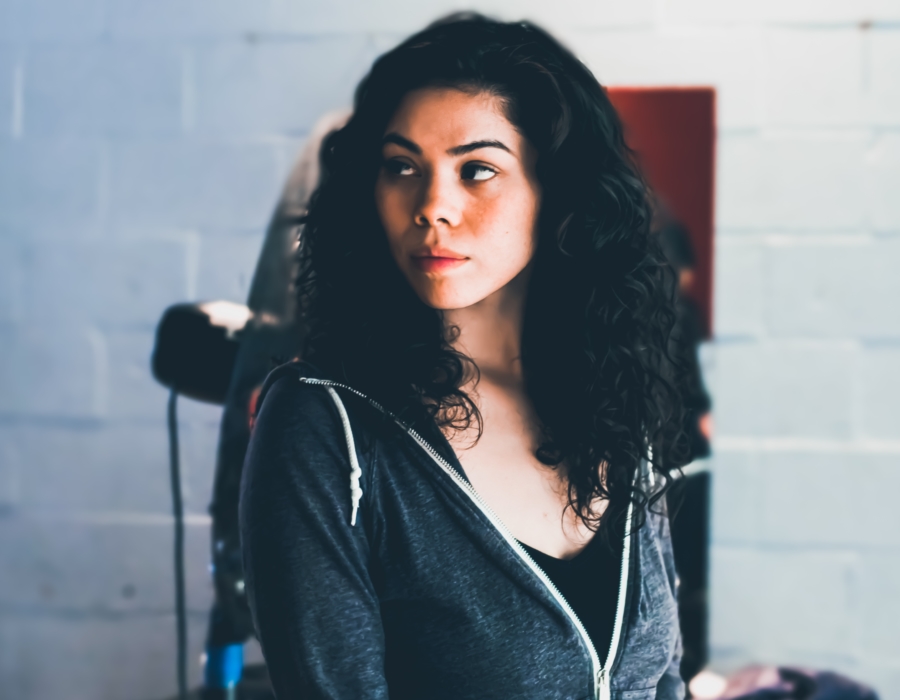A Native American woman in a hoodie and black top. Photo courtesy of Obi Onyeador for Unsplash.