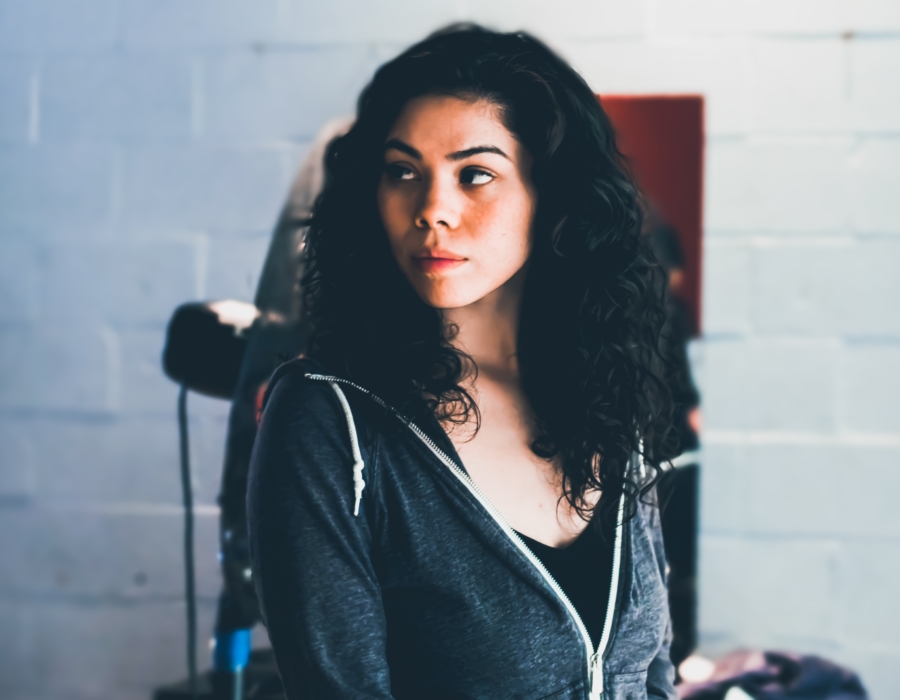 A Native American woman in a hoodie and black top. Photo courtesy of Obi Onyeador for Unsplash.