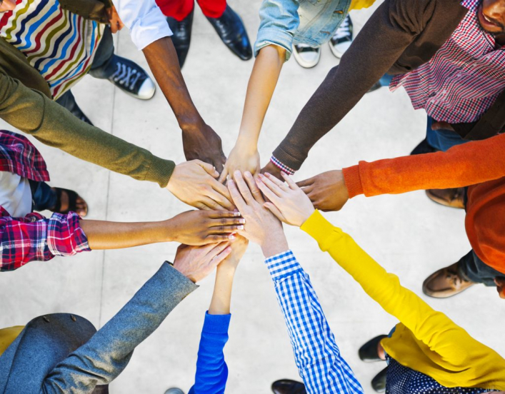 Ten people's arms coming together