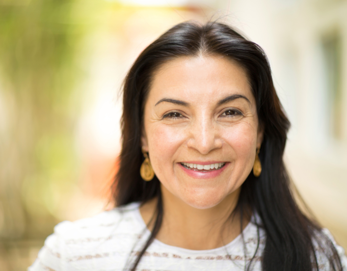 Picture of a Latina smiling in an outdoor setting.