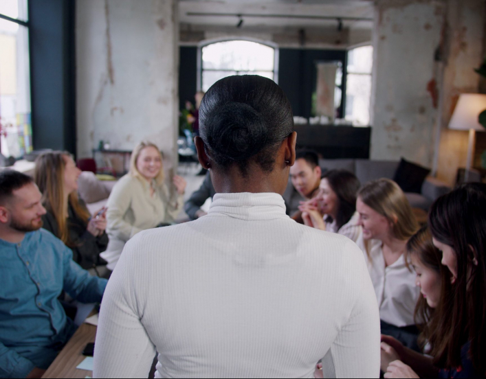 Woman standing in front of a conference room full of people