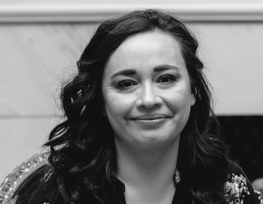 Black and white photo of a smiling latina woman.