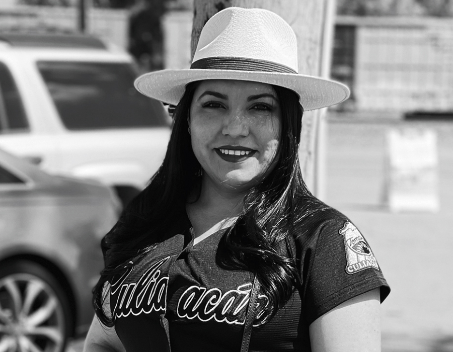 Black and white photo of a smiling latina woman in casual clothes.