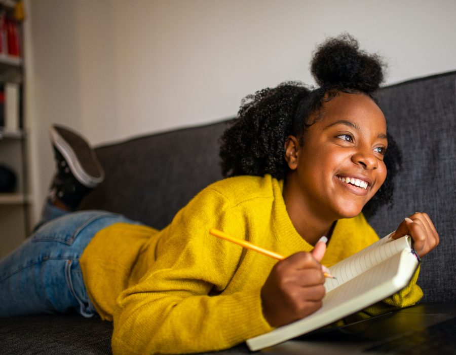 Teenager girl on sofa with notebook