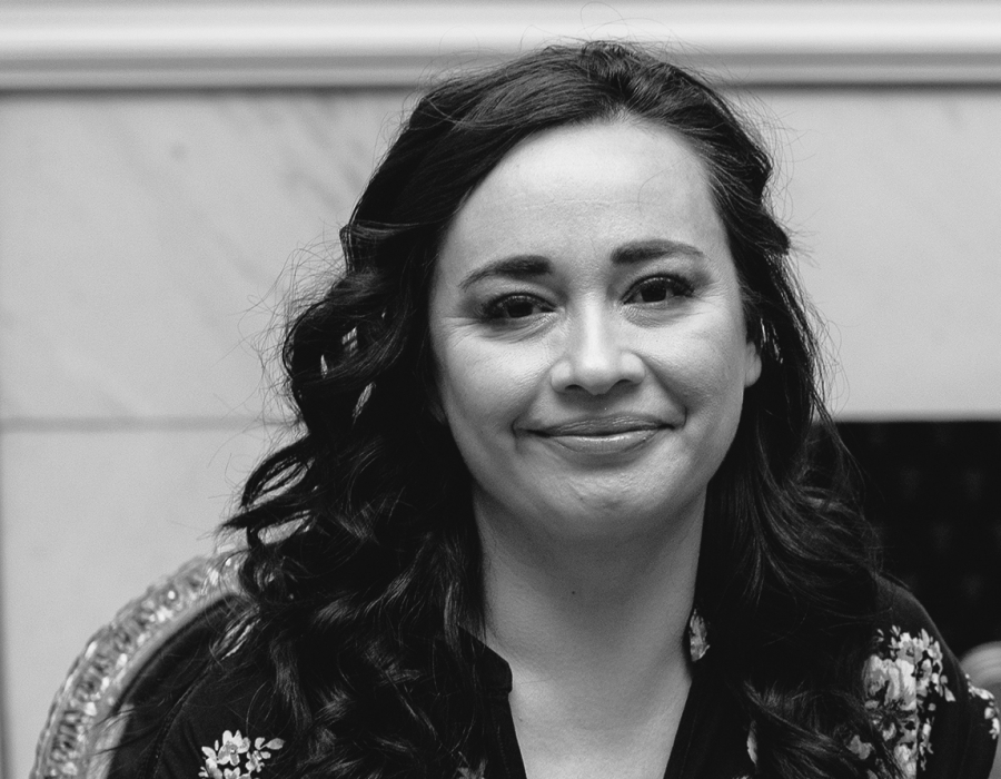 Black and white photo of a smiling latina woman.