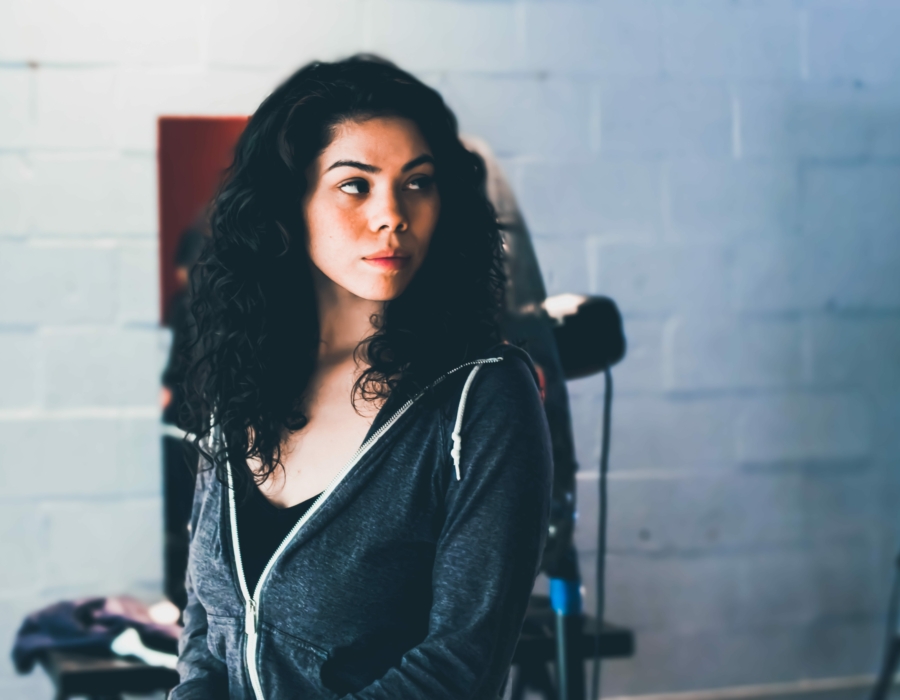 A Native American woman in a hoodie and black top. Photo courtesy of Obi Onyeador for Unsplash.
