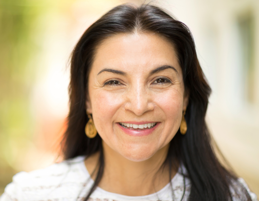Picture of a Latina smiling in an outdoor setting.