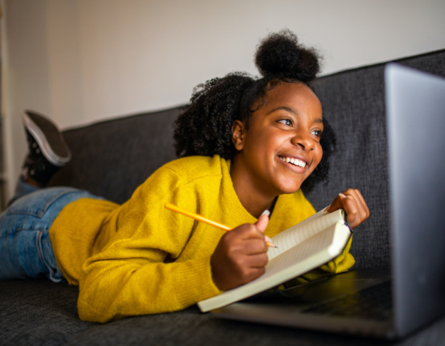 Teenager girl on sofa with notebook