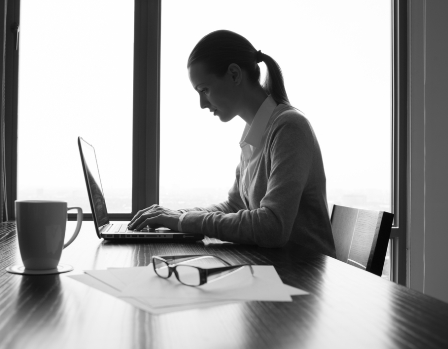A businesswoman using a laptop in a conference room